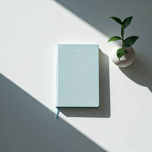 A minimalist and serene overhead shot of a light-colored journal on a pristine white desk.
